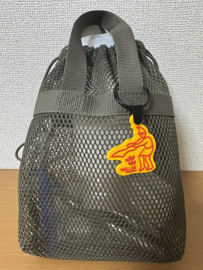 無印の立体メッシュ持ち手付き巾着にウェルビー福岡で買ったオレンジのキーホルダー