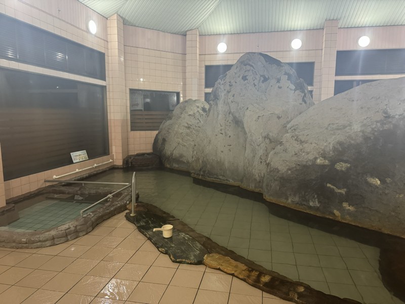 夜明薬湯温泉の内湯。大きな岩のある浴槽
